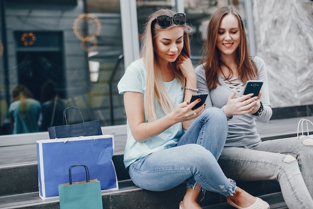 Ragazze carine con shopping bag in una città