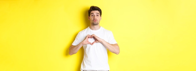 Foto gratuita simpatico ragazzo con le labbra arricciate e in attesa di un bacio che mostra il concetto di gesto del cuore di amore e romanticismo