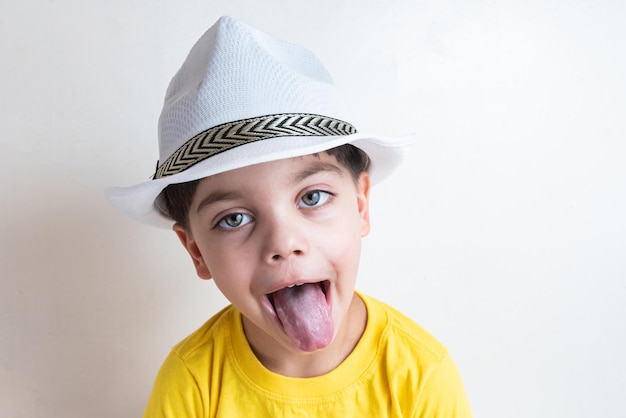 Cute and happy boy with yellow tshirt with white hat on head