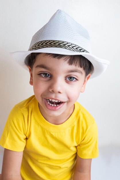 Cute and happy boy with yellow tshirt with white hat on head
