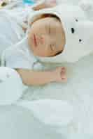 Free photo cute infant baby boy sleep with sweet dream and peaceful white soft bed