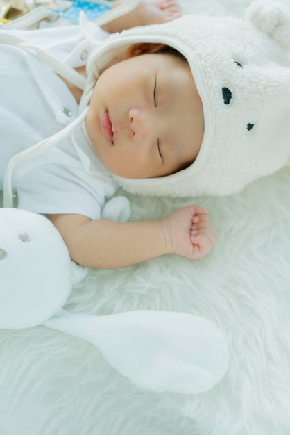 Cute infant baby boy sleep with sweet dream and peaceful white soft bed