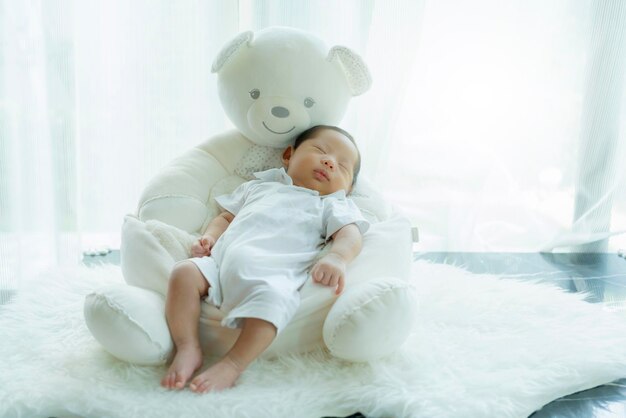 Cute infant baby boy sleep with sweet dream and peaceful white soft bed