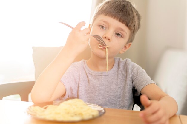 Cute kid eating spaghetti