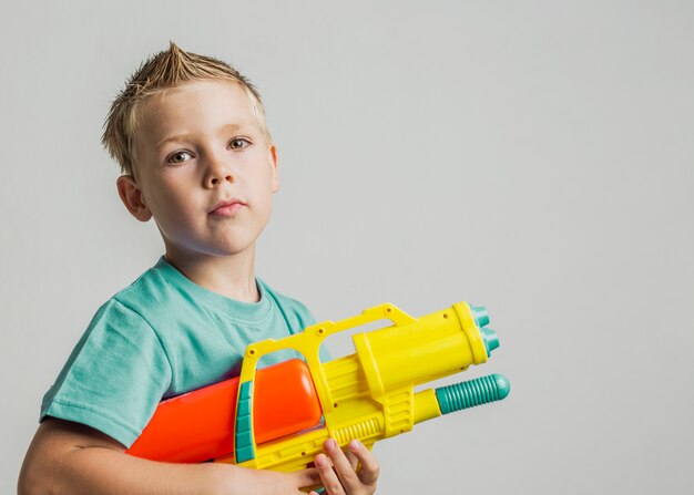 Cute kid playing with water gun