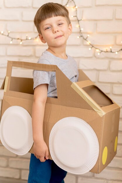 Cute kid with cardboard car