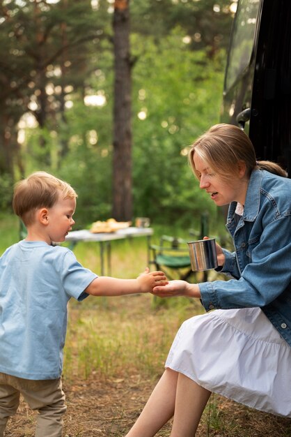 Cute kid with parent enjoying time in camping site