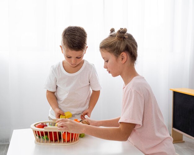 Cute kids cutting vegetables