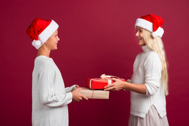 Cute kids holding christmas gifts