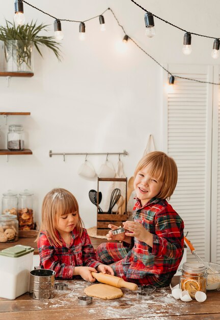 Cute kids making christmas cookies together in the kitchen