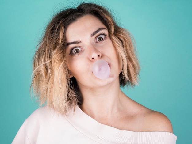 Free photo cute lady blowing bubble gum