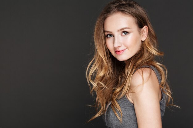 Cute lady posing over dark wall