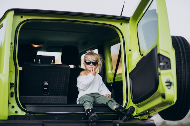 Cute little baby girl sitting in the back sit of the car