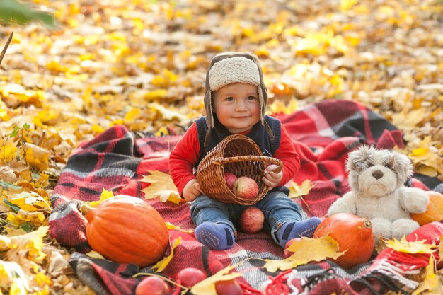 Милый маленький ребенок держит корзину с яблоками