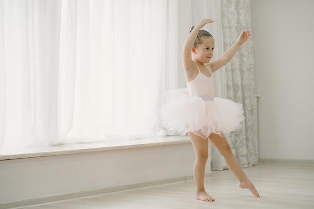 Cute Little Ballerinas In Pink Ballet Costume. Child In A Pointe Shoes Is Dancing In The Room. Kid In Dance Class.