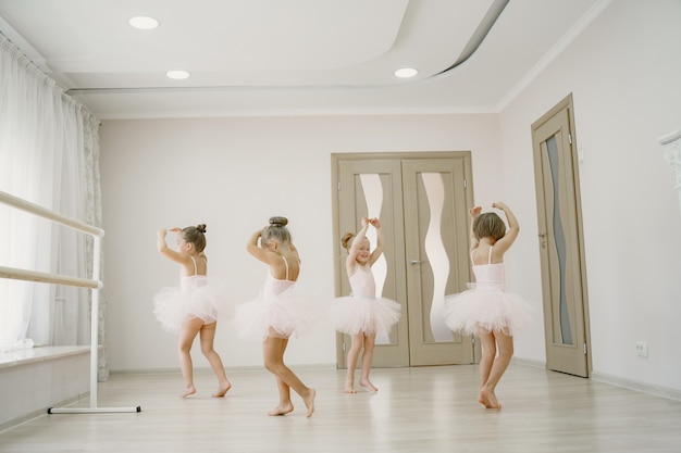 Cute Little Ballerinas In Pink Ballet Costume. Children In A Pointe Shoes Is Dancing In The Room. Kid In Dance Class.