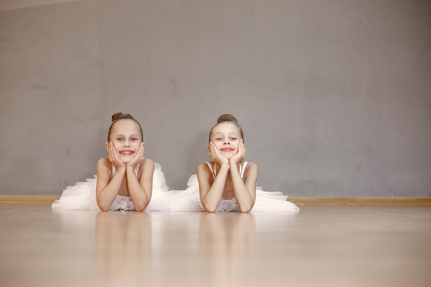 Piccole ballerine carine in costume da balletto bianco. i bambini in scarpe da punta sta ballando nella stanza. kid in classe di danza.