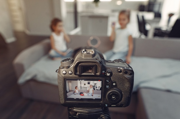 Cute little blogger with cosmetics recording video at home