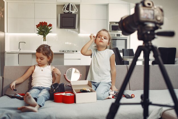 Cute little blogger with cosmetics recording video at home