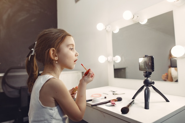 Милый маленький блоггер с косметикой записывает видео у себя дома