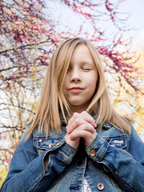 Cute little blonde girl praying