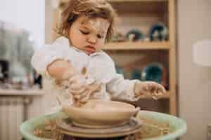 Free photo cute little boy at a pottery class