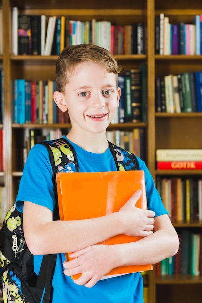 Cute little boy standing in library 