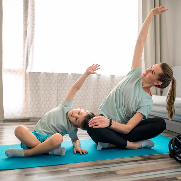 Cute little boy training together with mother