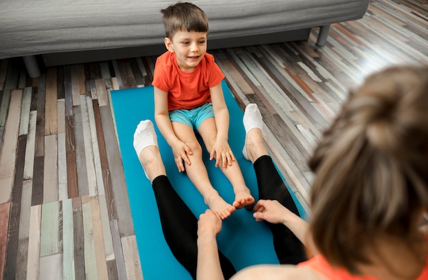 Free photo cute little boy training with mother at home