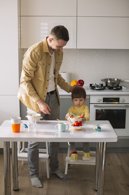 Cute little child and his father spending time in the kitchen