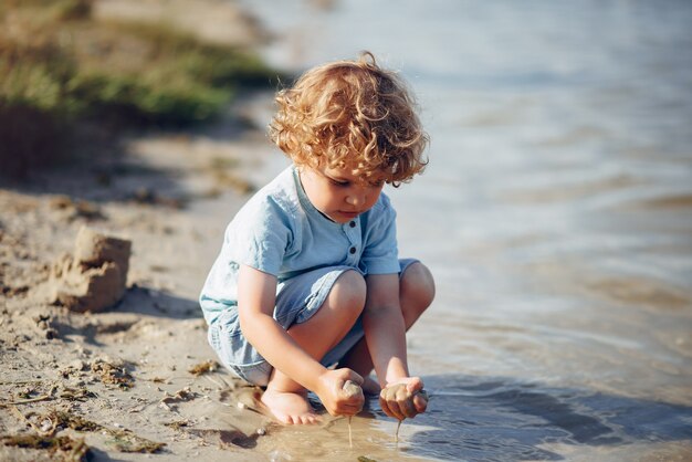 모래에 노는 귀여운 어린 아이