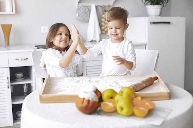 生地とキッチンに座っているかわいい子供たち