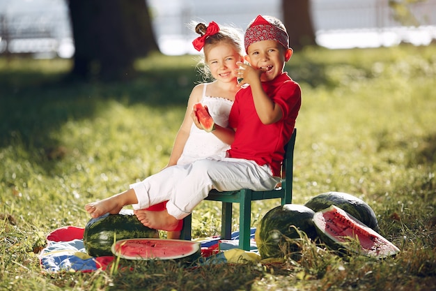 Cute little children with watermelons in a park