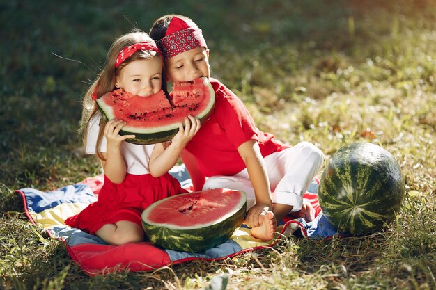 Cute little children with watermelons in a park