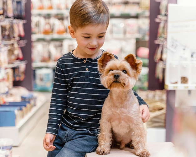 Foto gratuita simpatico cagnolino al negozio di animali con il proprietario