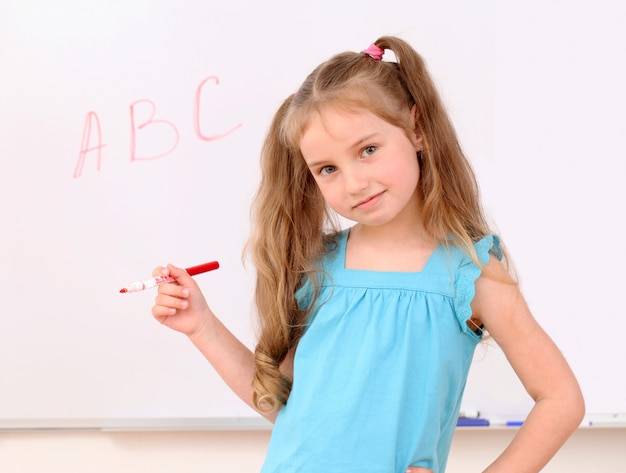 Cute little girl and ABC letters on board