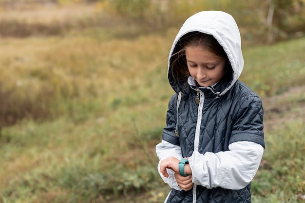 Foto gratuita bambina sveglia che regola il suo orologio