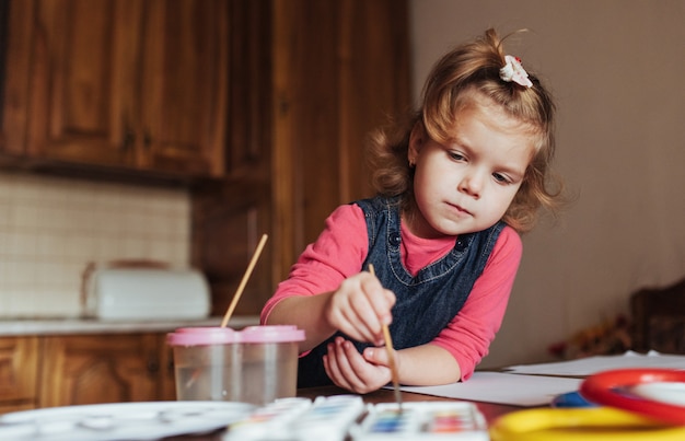Cute little girl, adorable preschooler painting with watercolors