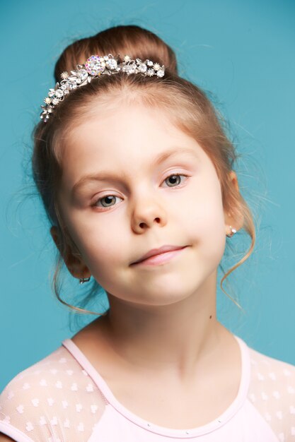 Cute little girl on a blue background close-up