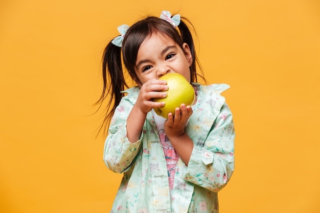 かわいい小さな女の子子食用リンゴ。