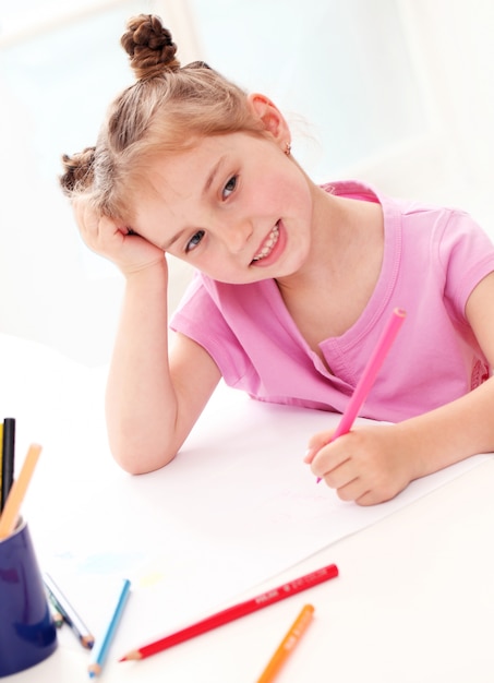 Free photo cute little girl drawing with colorful pencils