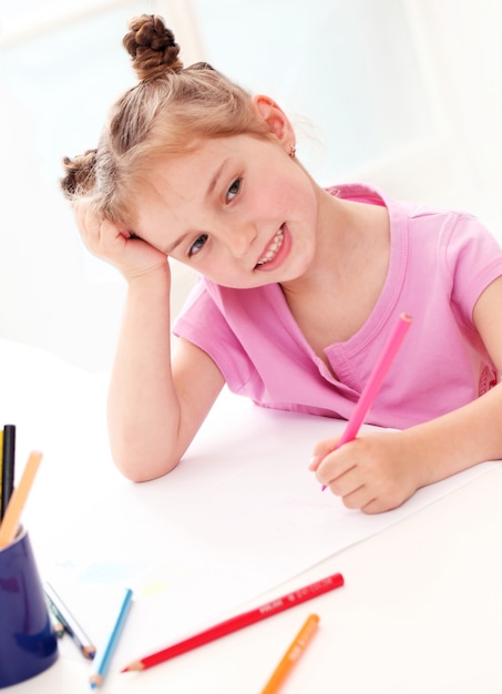 Милая маленькая девочка, рисование красочными карандашами