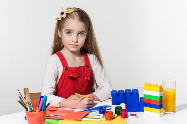 Cute little girl drawing with paint and paintbrush at home