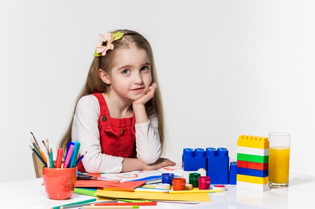 Cute little girl drawing with paint and paintbrush at home