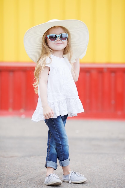 cute little girl in hat with backpack outdoor