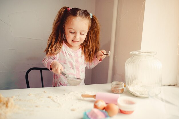 Cute little girl have fun in a kitchen