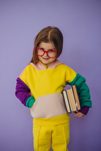 Cute little girl holding books isolated in studio