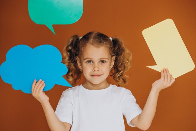 Cute little girl holding mind bubbles isolated in studio