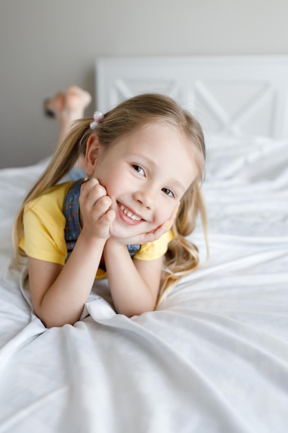 Foto gratuita bambina carina a casa a letto sorridente