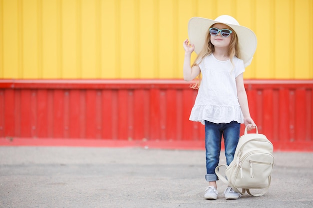 Бесплатное фото Милая маленькая девочка в солнечных очках и шляпе на открытом воздухе